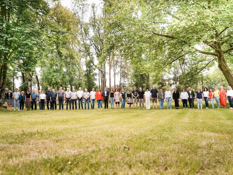 die städtischen Mitarbeiter in einer Reihe im Schlosspark, zwischen Bäumen