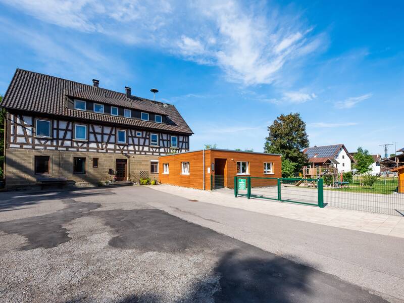 Kindergarten Eutendorf Außenansicht, im Hintergrund das ältere Gebäude, vorne rechts ein modernen hölzerner Anbau