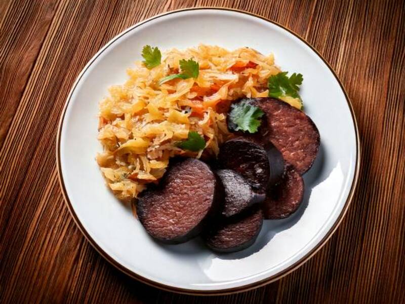 KI teller mit blutwurst und leberwurst, fleisch, sauerkraut auf einem holztisch