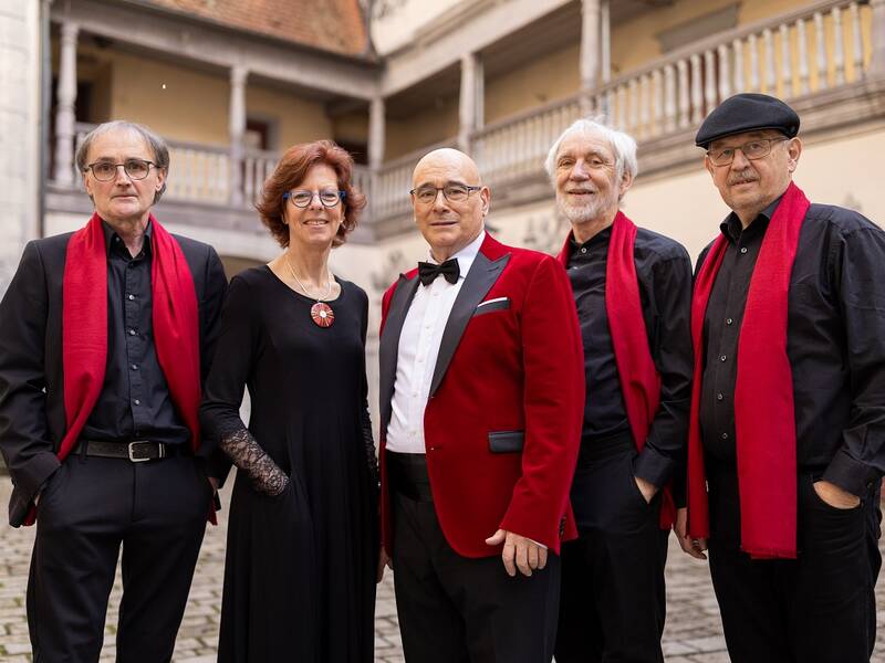 Vistoso Ensemble, fünf Menschen mit roten Schals im Innenhof des Alten Schlosses stehen